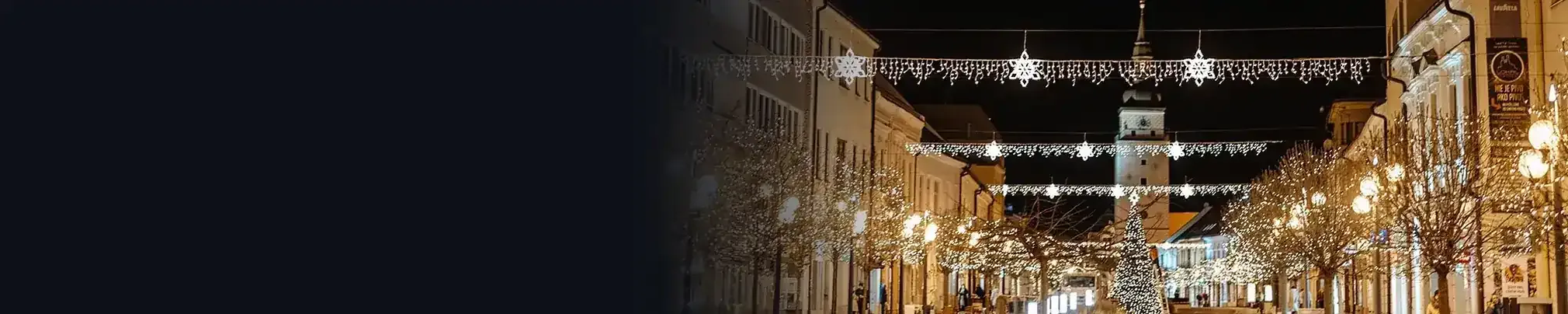Noční ulice s vánoční světelnou výzdobou přes ulici a na sloupech
